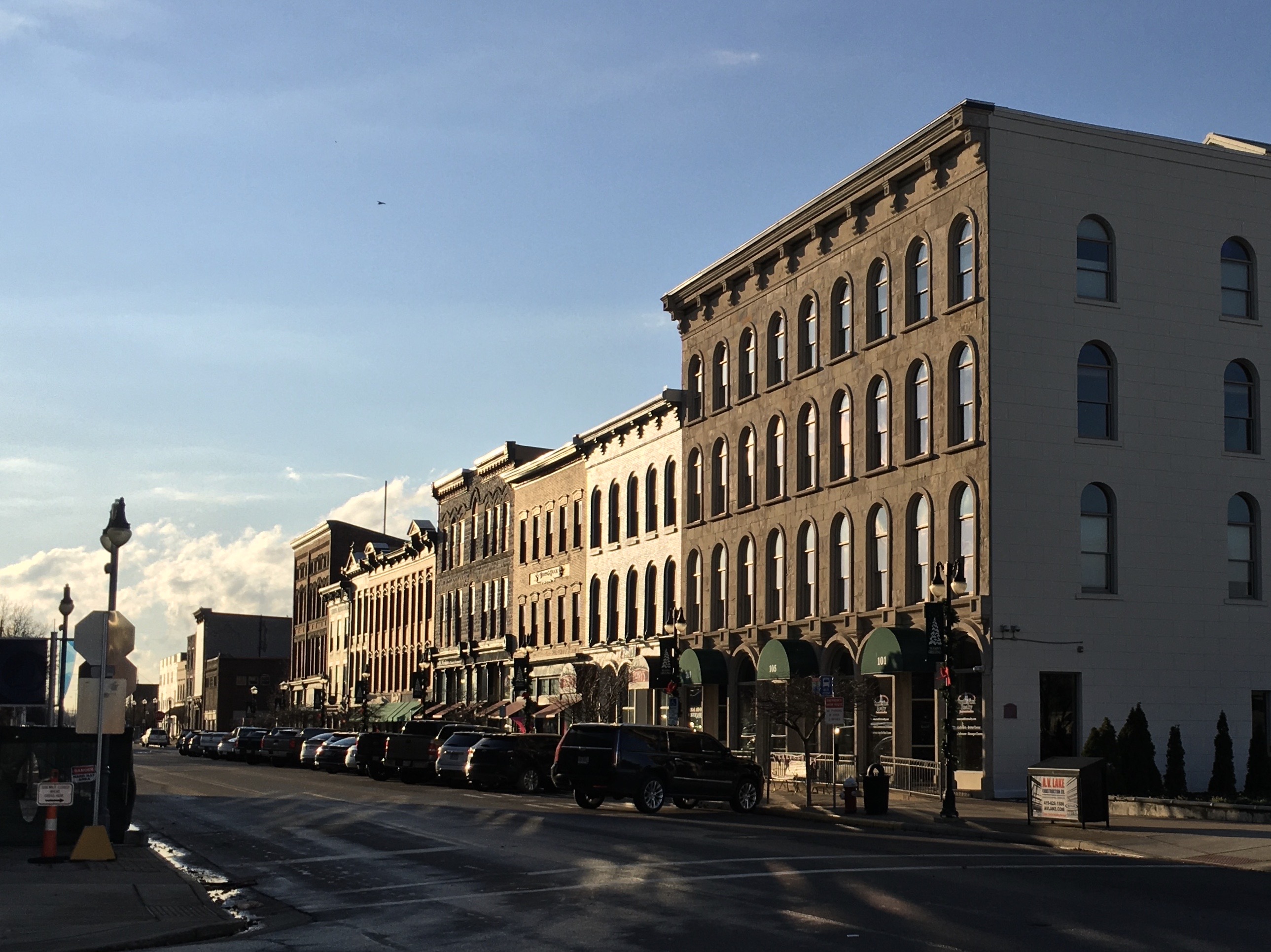 Brick storefronts and parked cars along West Water Street in downtown Sandusky.