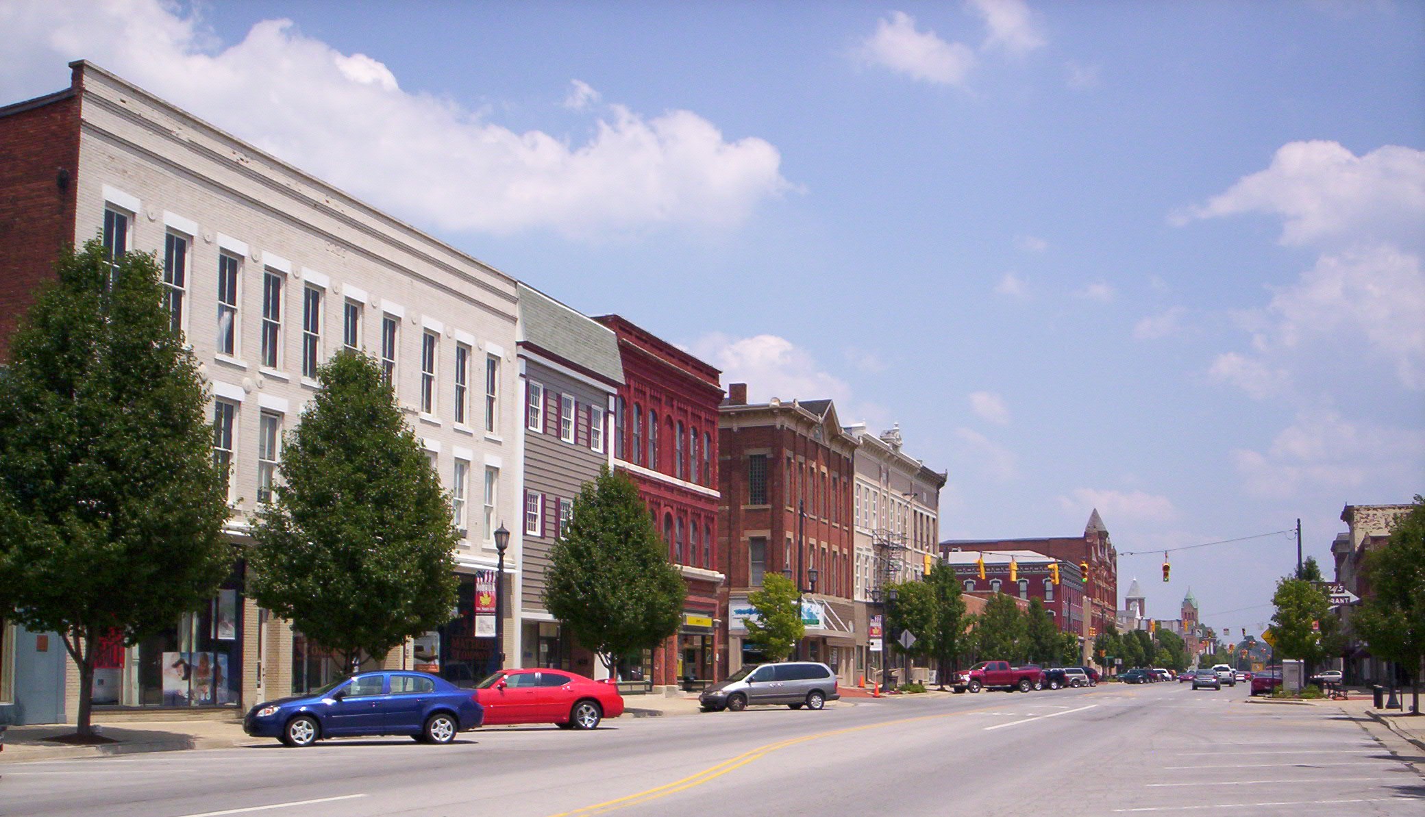 Brick storefronts and parked cars line West Main Street in downtown Norwalk.